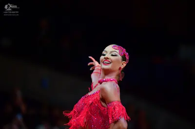 Dancesport competitor: Female dancer: red latin dress with sequins and fringe, with a matching sequined