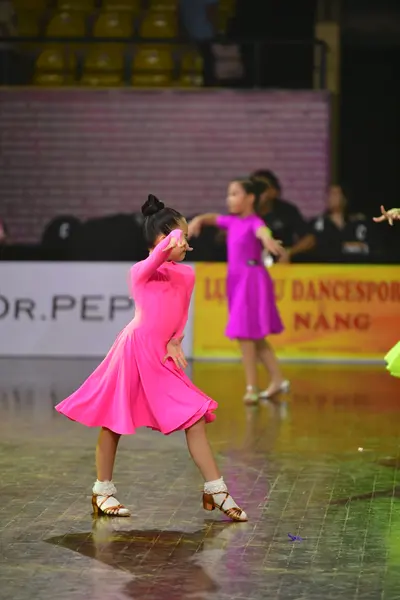 Dancesport competitor: Female dancer: bright pink long-sleeved latin dress