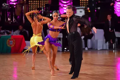 Dancesport competitor: Male dancer: black long-sleeve shirt with sheer mesh and black trousers