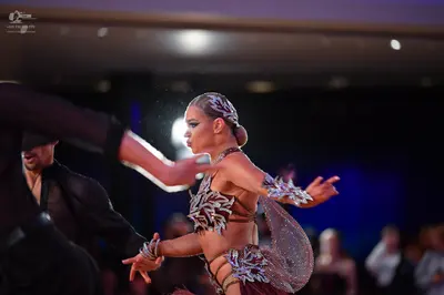 Dancesport competitor: Female dancer: burgundy latin dance costume with silver sequin patterns and matc