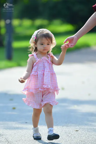 Dancesport competitor: Child dancer: pink and white gingham sleeveless ruffled romper, white lace headb