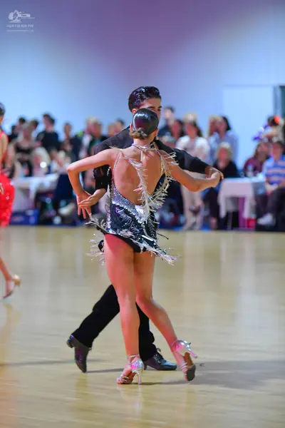 Dancesport competitor: Female dancer: black Latin dance outfit with silver/white shimmering fringe or s