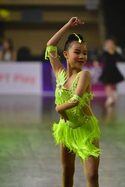 Dancesport competitor: Female dancer: neon green Latin dress with fringe and sequins, matching neon gre