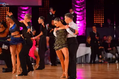 Dancesport competitor #652: Male dancers: black long-sleeved shirts and black trousers, and one white long-s