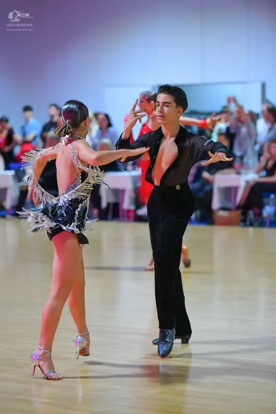 Dancesport competitor: Female dancer: black Latin dress with silver/white fringe and sequins