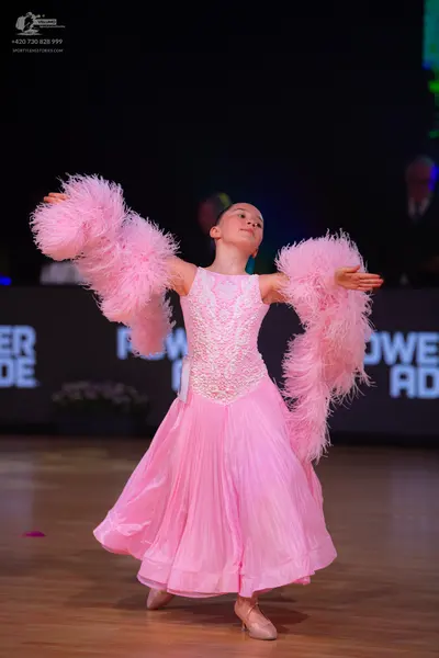 Dancesport competitor: Female dancer: pink ballgown with a lace/sequined bodice, a voluminous flowing s