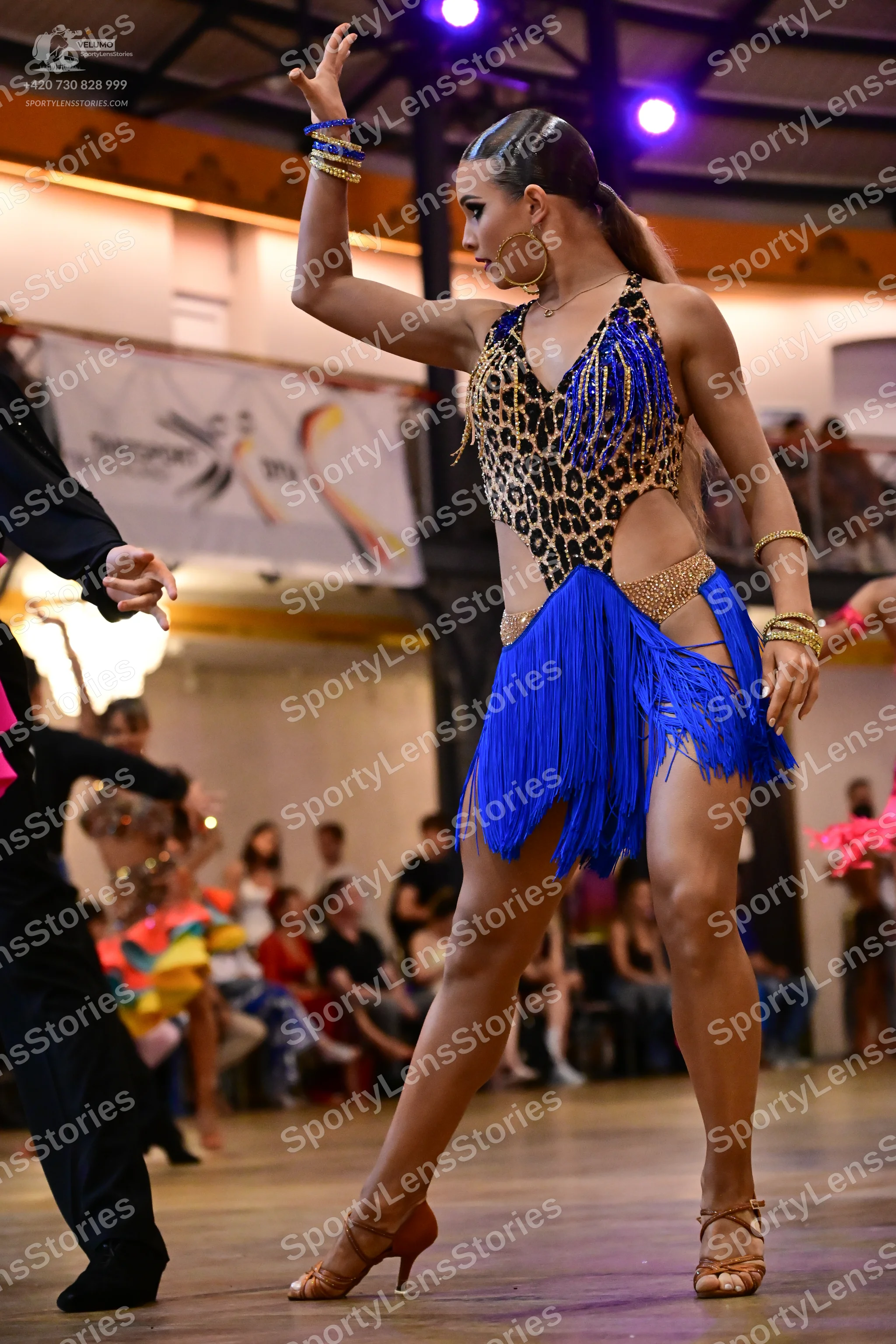 Dancesport competitor: Female dancer: blue and leopard print latin dance costume with fringe skirt, gol