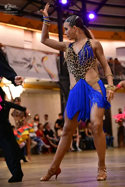 Dancesport competitor: Female dancer: blue and leopard print latin dance costume with fringe skirt, gol