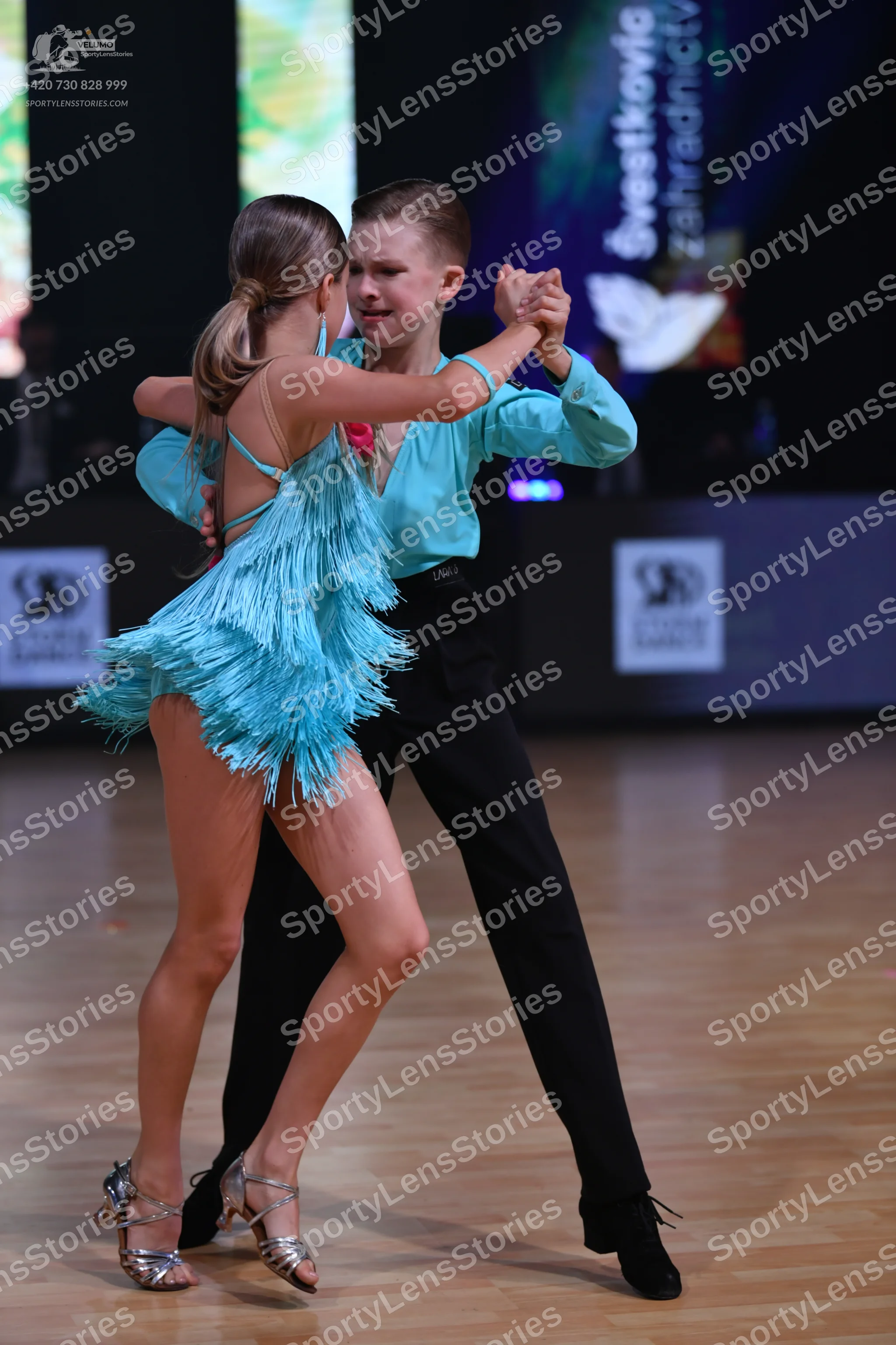 Dancesport competitor: Female dancer: aqua blue Latin dress with long fringe and thin straps
