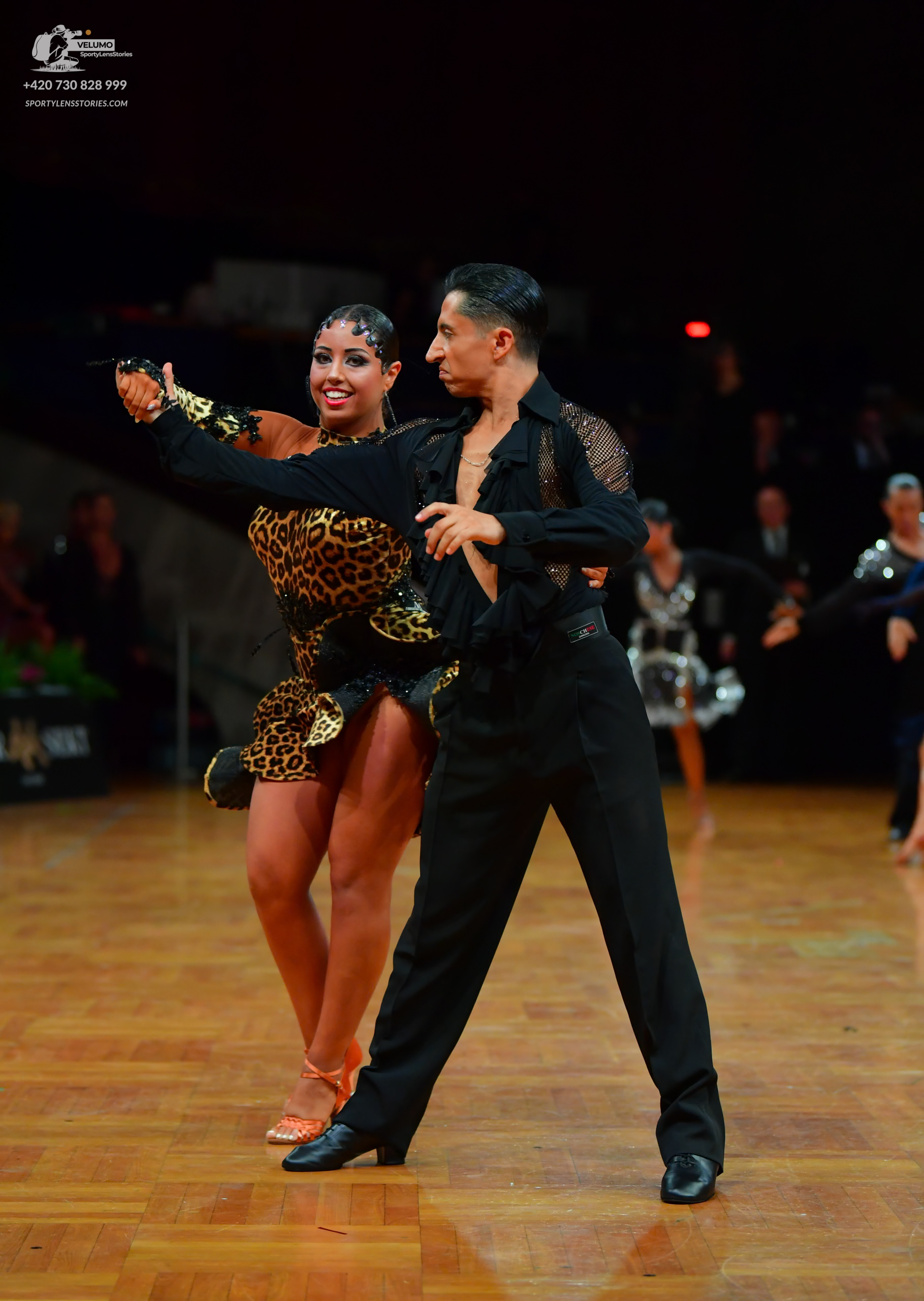 Dancesport competitor: Female dancer: leopard print Latin dress with black lace sleeves