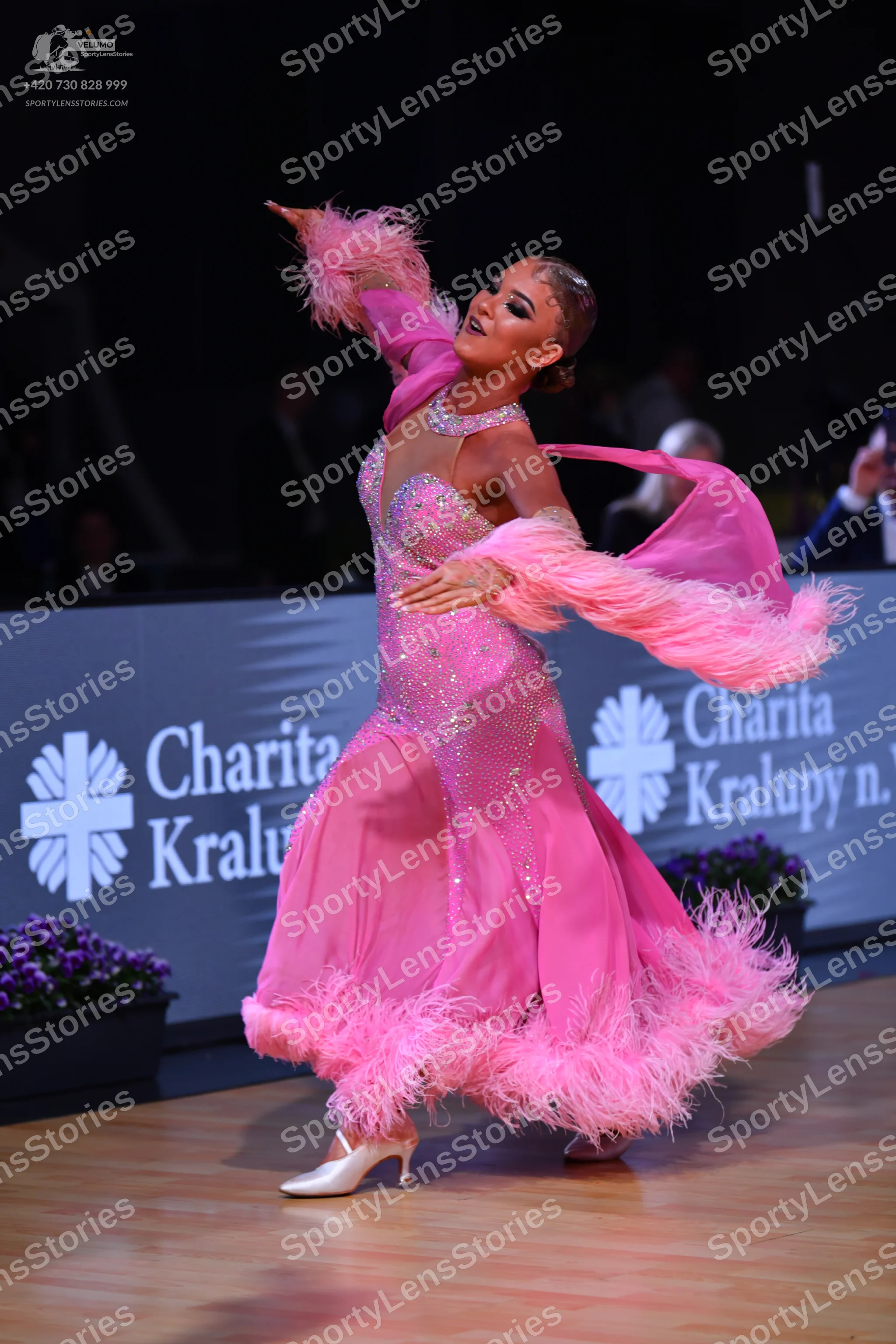 Dancesport competitor: Female dancer: bright pink latin dress with a sequin-covered bodice, sheer mesh