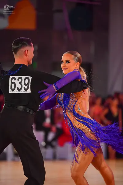 Dancesport competitor #639: Male dancer: black long-sleeved shirt with blue sequins on the shoulders and bla