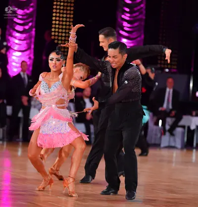 Dancesport competitor: Female dancer: pink Latin dance dress with sequins, cutouts, and fringe