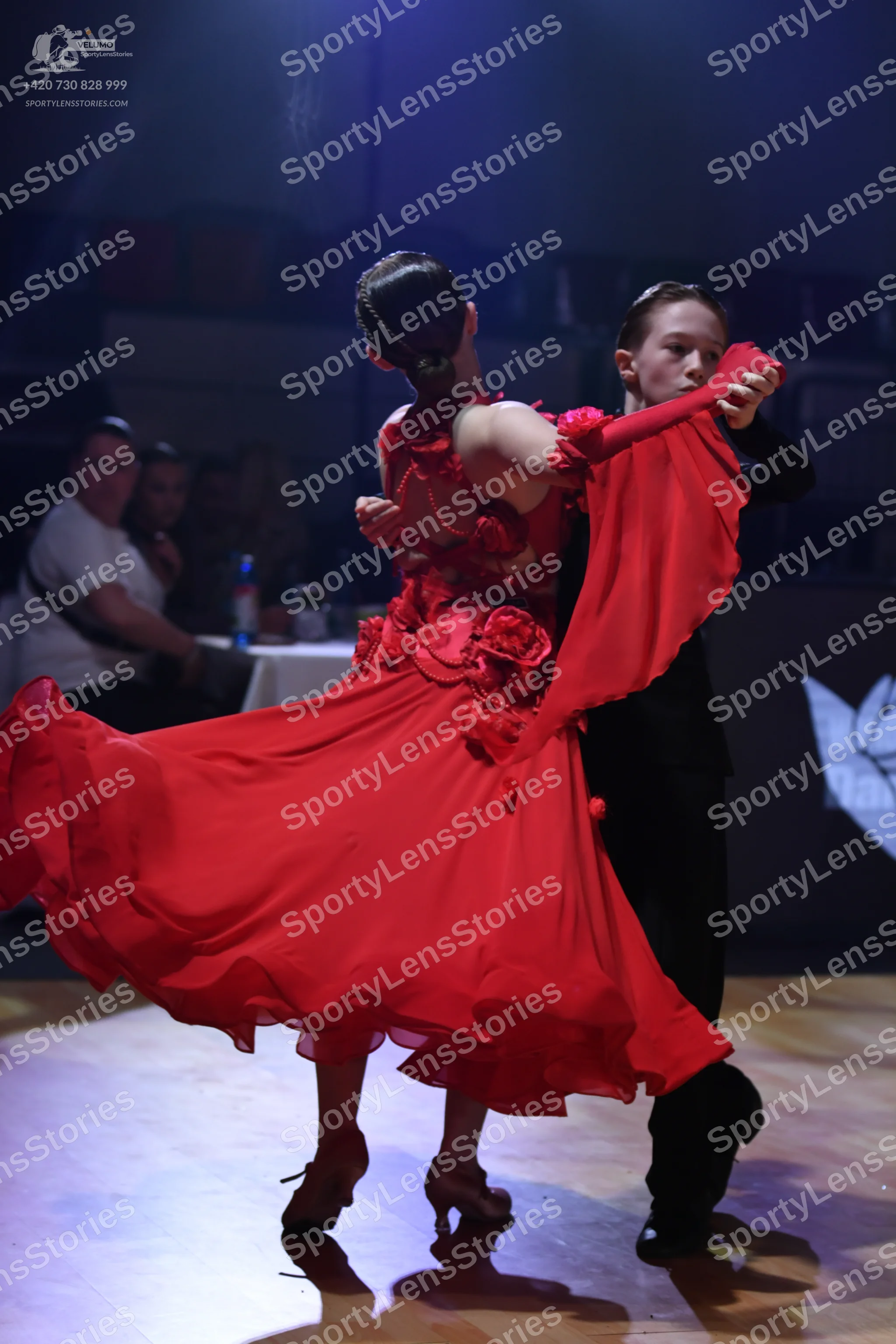 Dancesport competitor: Female dancer: red ballroom dress with a full, flowing skirt and red floral embe