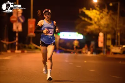 Marathon runner #138: Runner 1: blue tank top, black shorts, white socks, white shoes, a dark cap, and