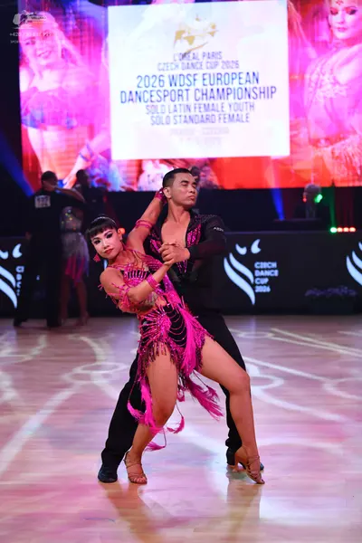 Dancesport competitor: Female dancer: magenta latin dress with sequins and long fringe