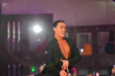 Dancesport competitor: Male dancer: black long-sleeved dance top, open at the chest