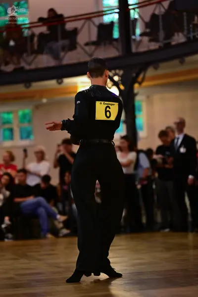 Dancesport competitor: Male dancer: black long-sleeved shirt and black trousers