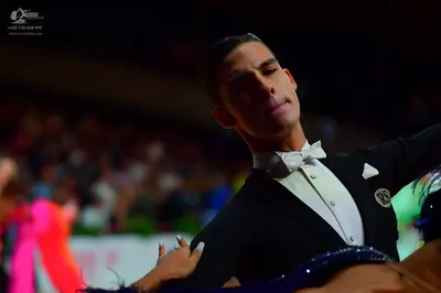 Dancesport competitor: Male dancer: black suit with white shirt, white bow tie, and a white pocket squa