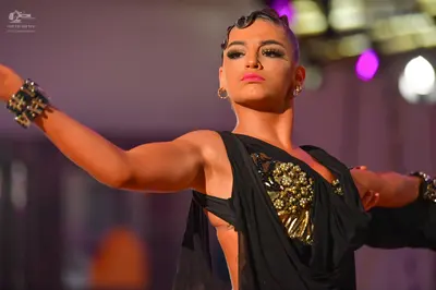 Dancesport competitor: Female dancer: black latin dress with gold and silver sequin embellishments on t