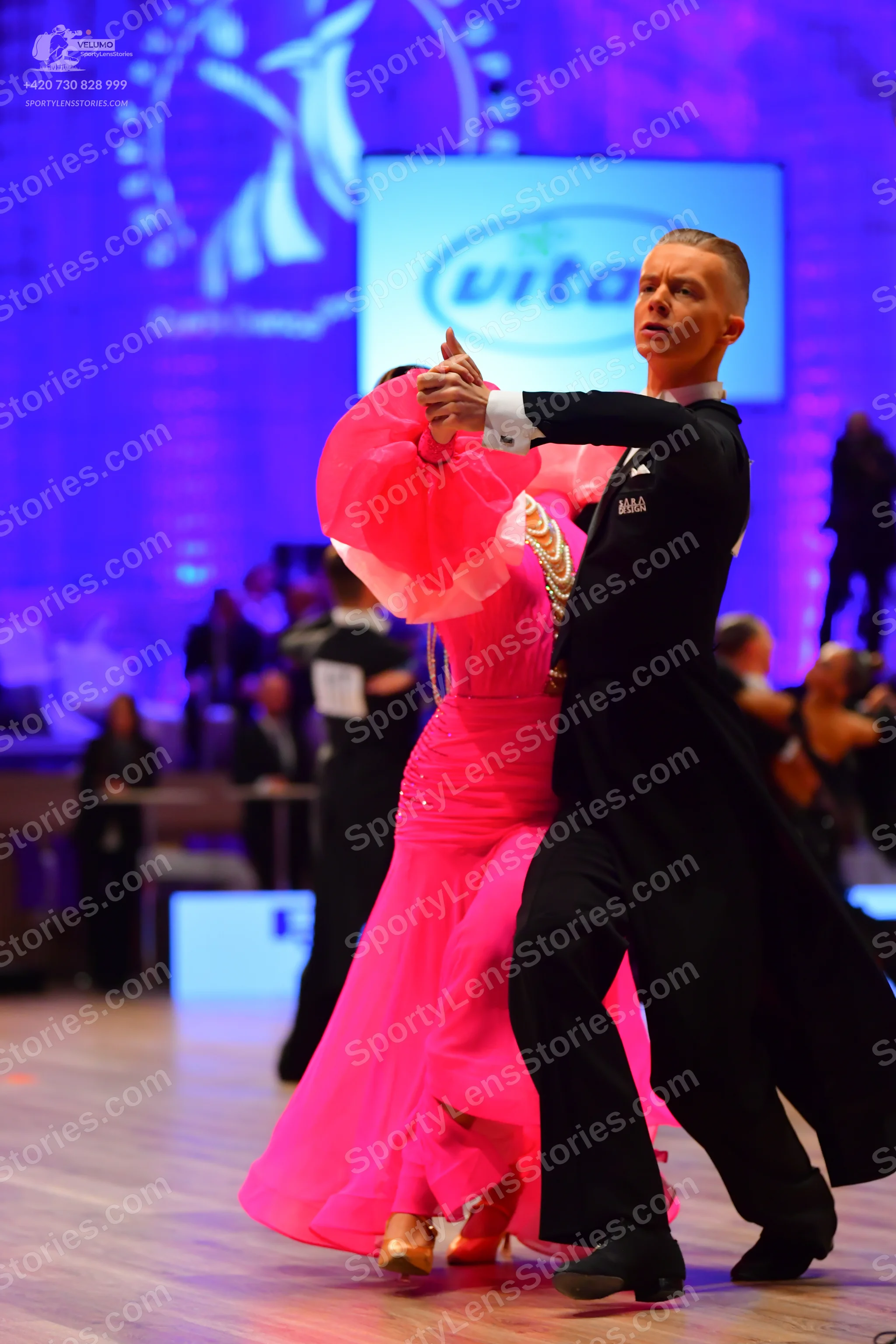 Dancesport competitor: Male dancer: black ballroom suit with white shirt collar and cuffs