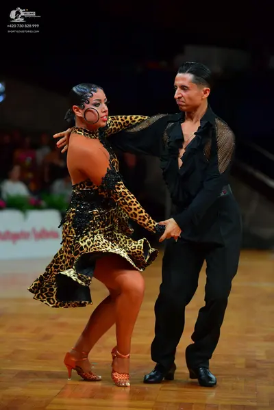 Dancesport competitor: Female dancer: leopard print Latin dress with black sequin embellishments and ta