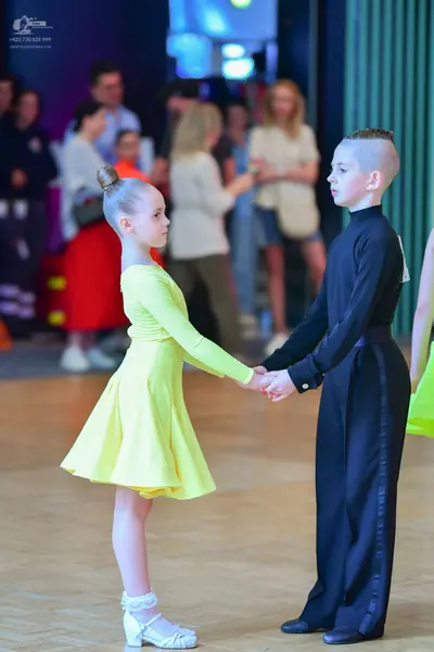 Dancesport competitor: Female dancer: yellow long-sleeved dress with a flared skirt