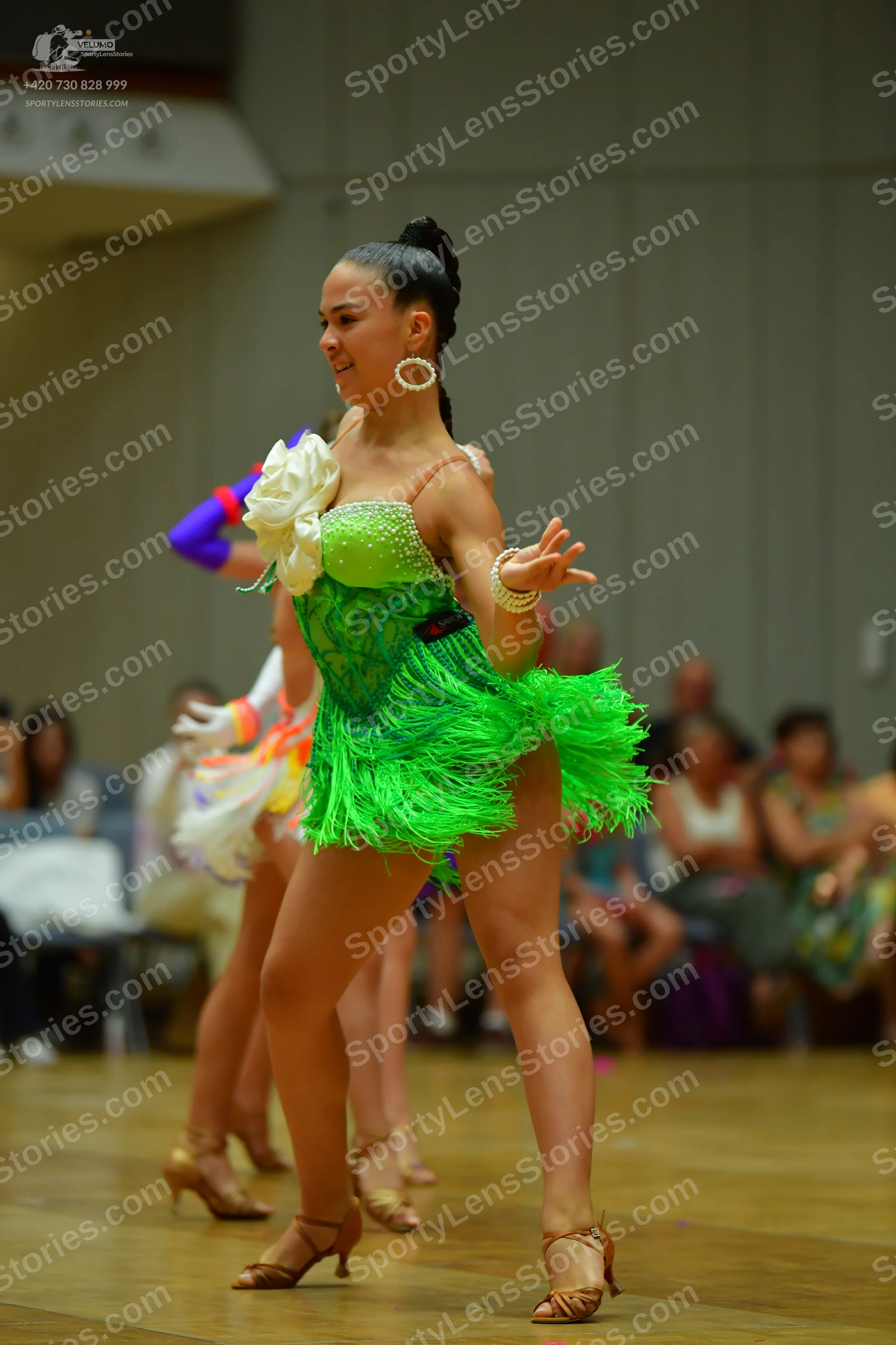 Dancesport competitor: Female dancer: mint green sequin top and bright green fringe Latin dress with a 