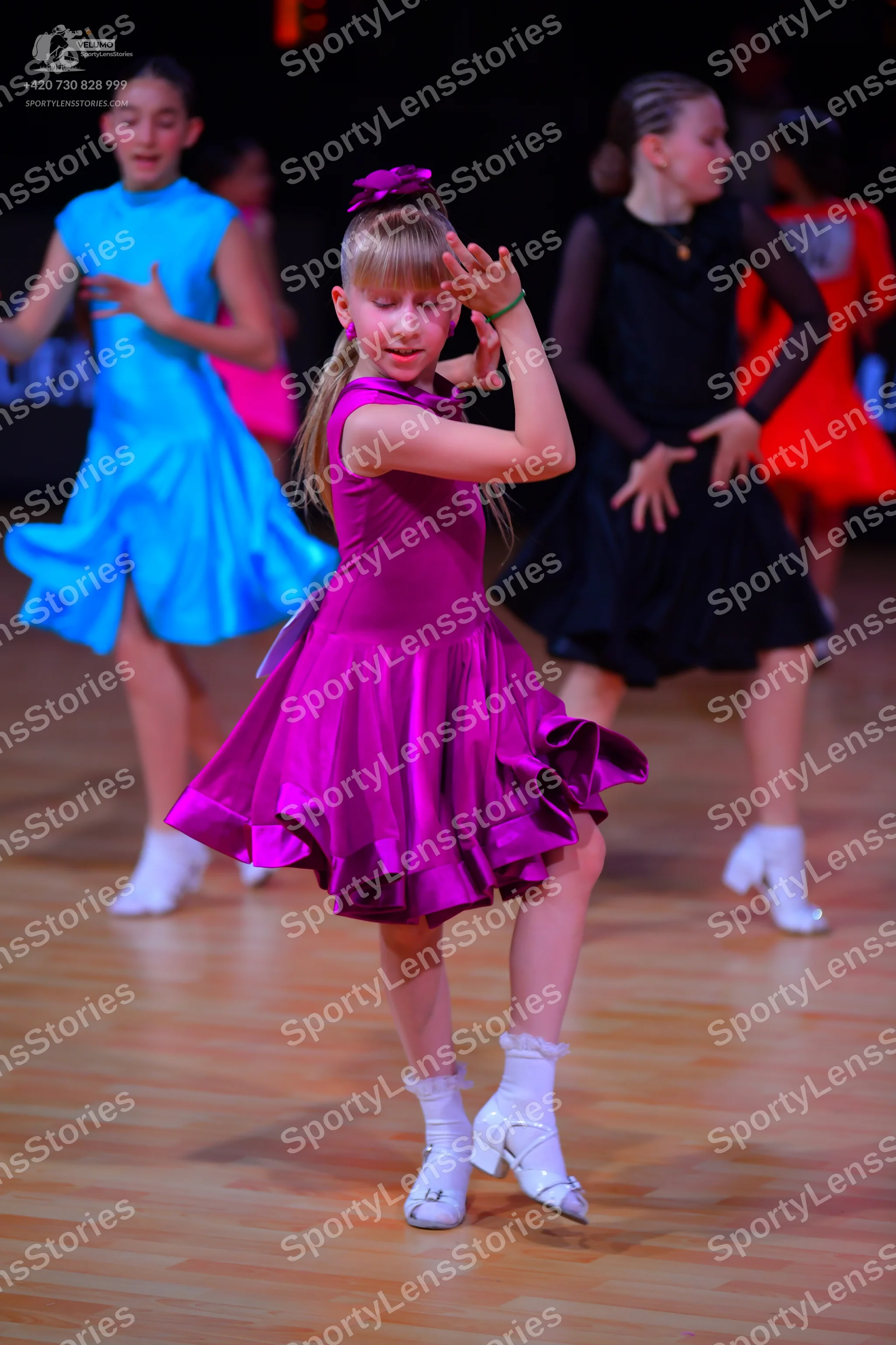 Dancesport competitor: Female dancer 1: light blue sleeveless satin-like latin dress with a flared skir