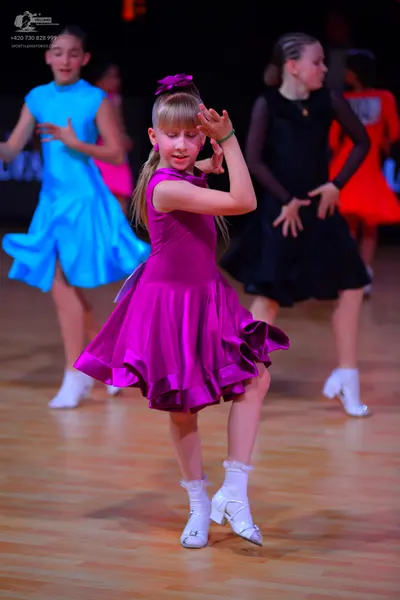 Dancesport competitor: Female dancer 1: light blue sleeveless satin-like latin dress with a flared skir