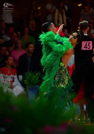 Dancesport competitor: Female dancer: green sequined Latin dress with heavy textured embellishments