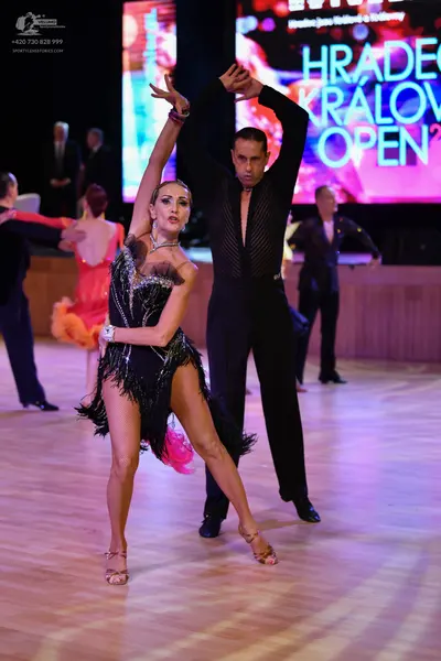 Dancesport competitor: Male dancer: black long-sleeved shirt with textured/sequined bodice and black tr
