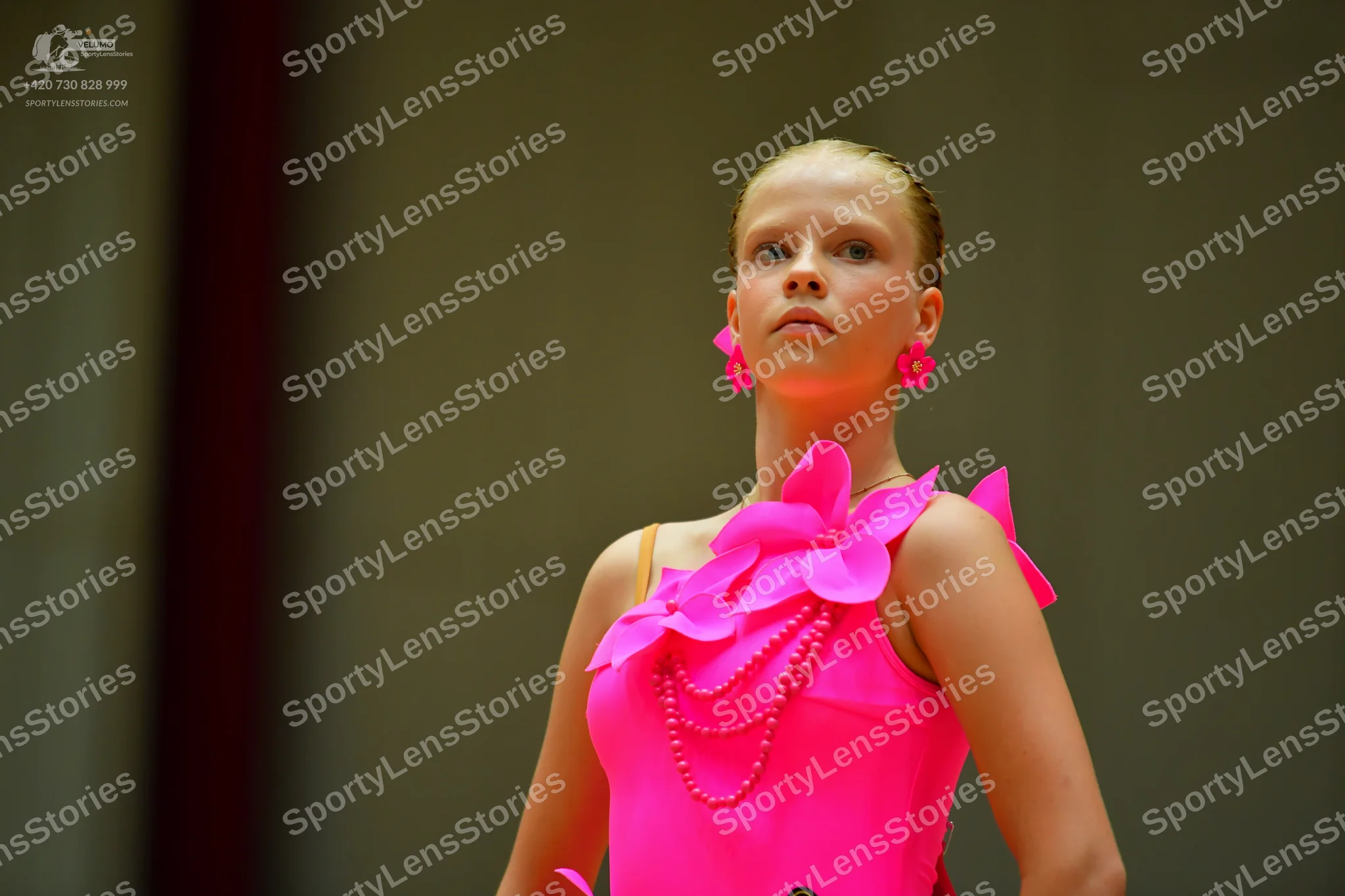 Dancesport competitor: Female dancer: bright pink Latin-style dance dress with large 3D fabric flower p