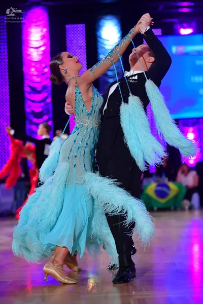 Dancesport competitor: Female dancer: light blue latin dress with sequins and large feather-like fringe