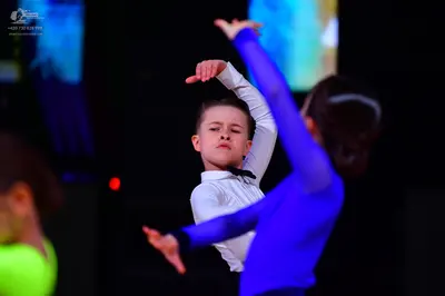 Dancesport competitor: Male dancer: white long-sleeved shirt with a black bowtie and black trousers