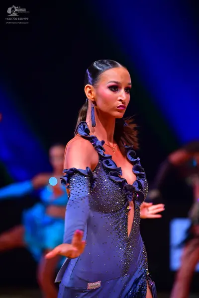 Dancesport competitor: Female dancer: dark blue latin dress with sequins and ruffles