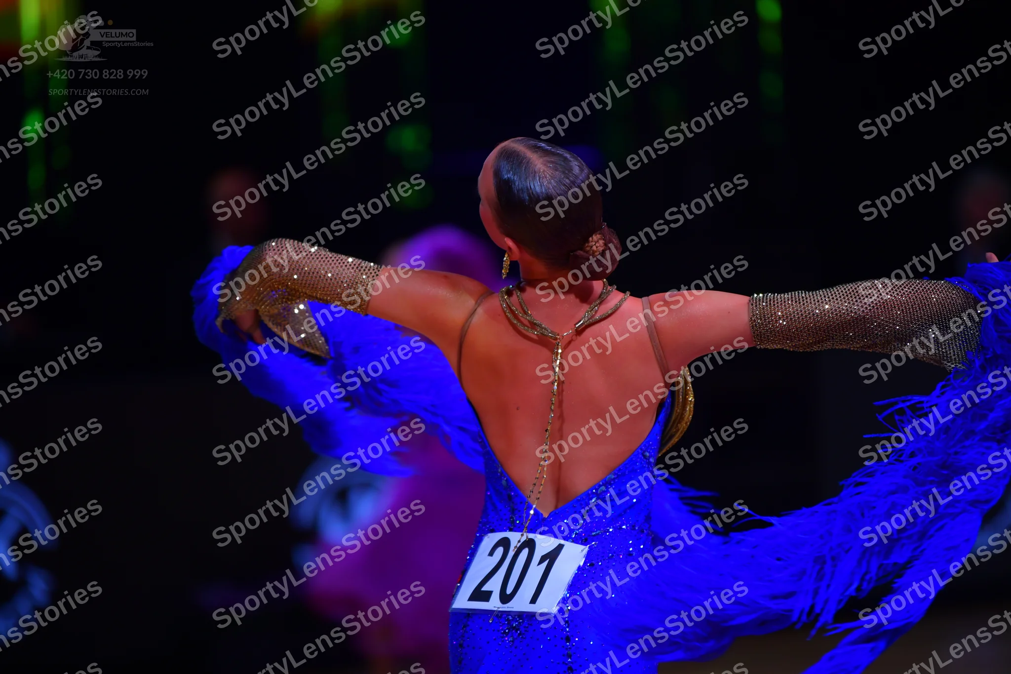 Dancesport competitor: Female dancer: bright blue Latin dress with sequins and long blue fringes, featu
