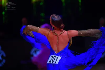 Dancesport competitor: Female dancer: bright blue Latin dress with sequins and long blue fringes, featu