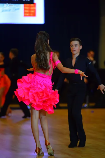 Dancesport competitor: Female dancer: bright pink ruffled latin dress