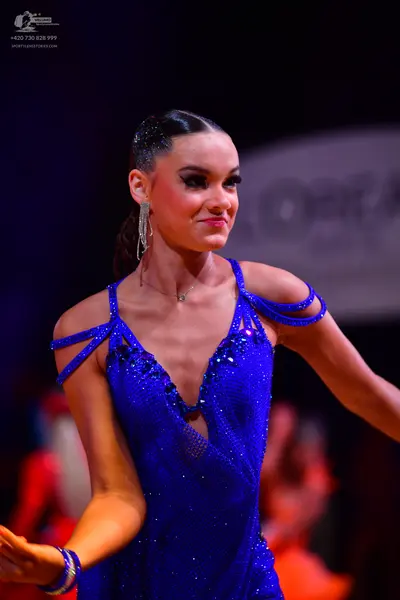 Dancesport competitor: Female dancer: royal blue latin dress made of sequined fabric with thin straps a