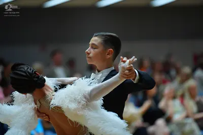 Dancesport competitor: Male dancer: black suit with a white shirt and a white bow tie