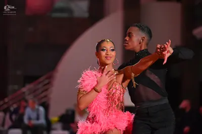 Dancesport competitor: Female dancer: pink Latin dress with feather details and a sequined/beaded bodic