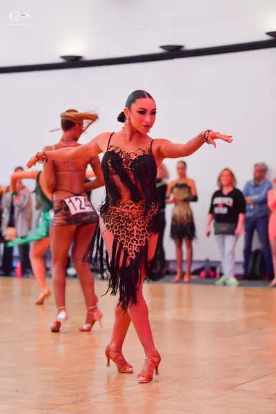 Dancesport competitor #124: Female dancer in foreground: leopard print latin dress with black fringe, black 