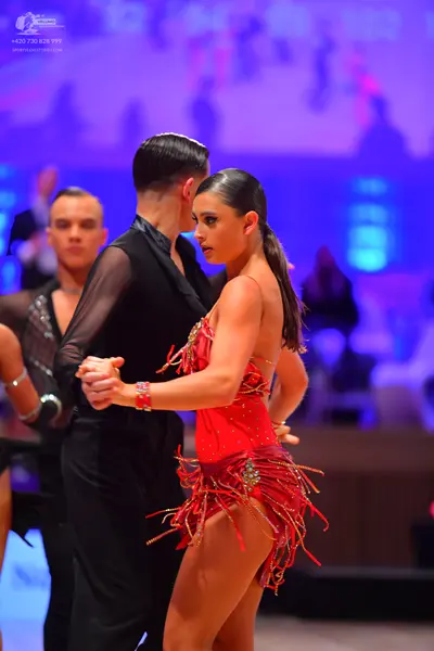 Dancesport competitor: Male dancer: black shirt with sheer mesh sleeves and black trousers