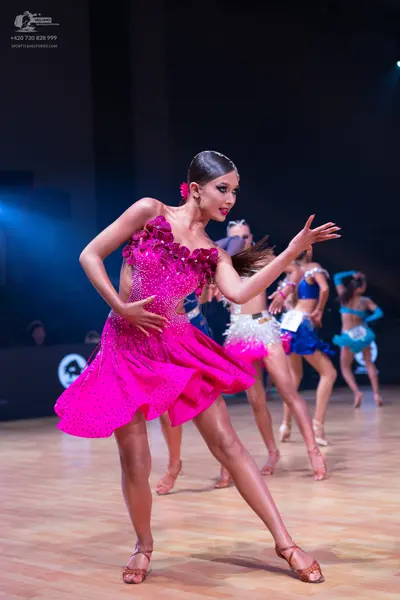 Dancesport competitor: Female dancer 1: pink sequin latin dress with an asymmetrical, ruffled design