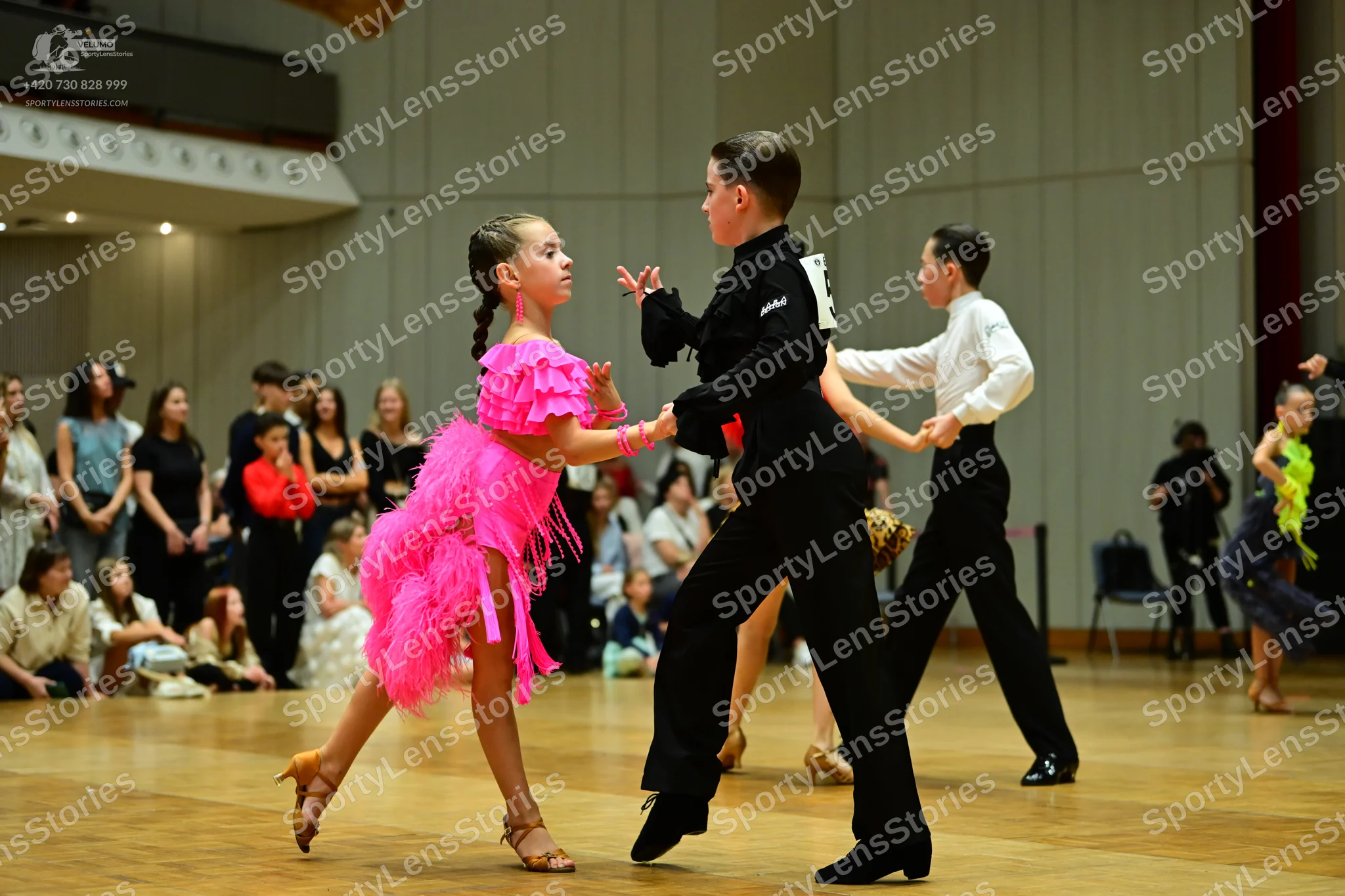 Dancesport competitor: Female dancer: bright pink latin dress with layers of fringe