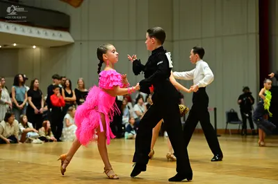 Dancesport competitor: Female dancer: bright pink latin dress with layers of fringe