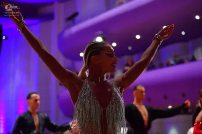Dancesport competitor: Female dancer: silver latin dress with heavy fringe and sequins, wearing bracele