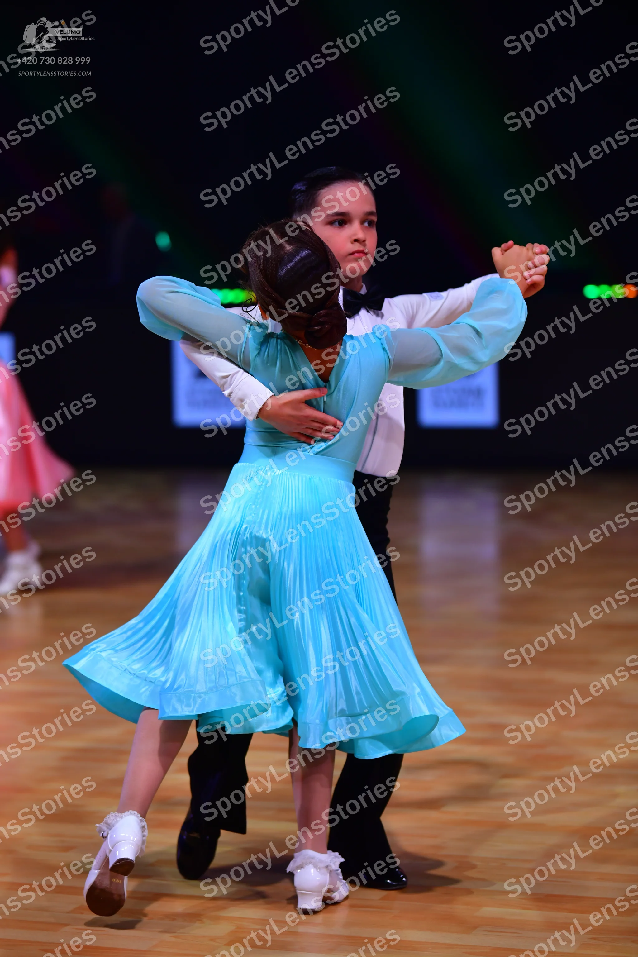 Dancesport competitor: Female dancer: light blue long-sleeved pleated ballroom dress