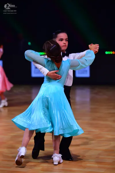 Dancesport competitor: Female dancer: light blue long-sleeved pleated ballroom dress